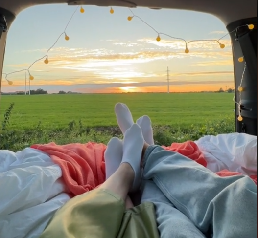 Romantische kofferbakdate met dekens, snacks en uitzicht op zonsondergang